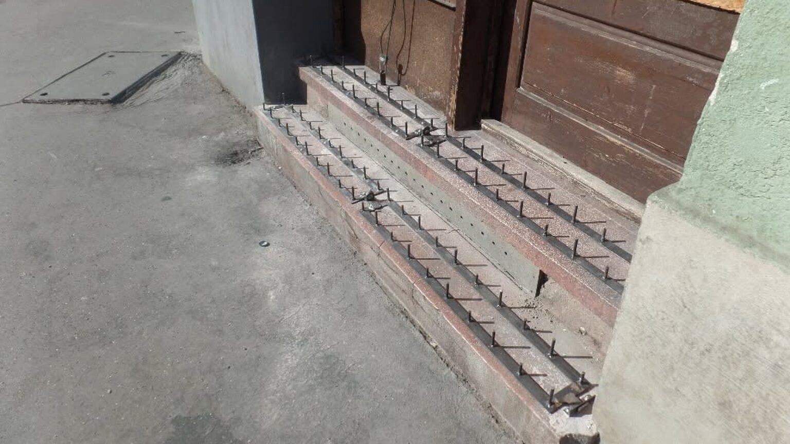 Egy józsefvárosi bejárat lépcsőjére szerelt fém tüskesorok, amelyek megakadályozzák, hogy leüljenek rá