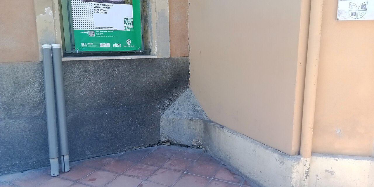 Ferde kőkitöltés egy épület sarkában Nizzában, amely visszaveri a falra vizelők sugarát